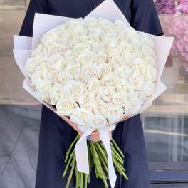 Large bouquet of white roses wrapped in pale paper