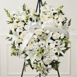 White floral heart wreath with a satin ribbon on a black easel