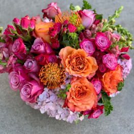 Bouquet of pink and orange roses with lavender hydrangea and orange pincushion blooms