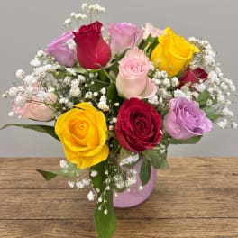 Colorful rose bouquet in a pink vase with baby's breath
