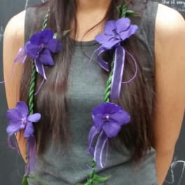 Woman wearing a purple flower lei with ribbon accents