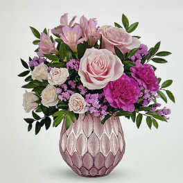 Pink and white flower arrangement in a textured pink vase