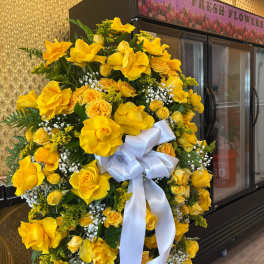 Large yellow floral wreath with a white ribbon bow