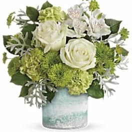 White roses and green flowers in a glass vase