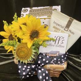 Sunflowers in a basket with caramel popcorn, nuts, and coffee toffee.