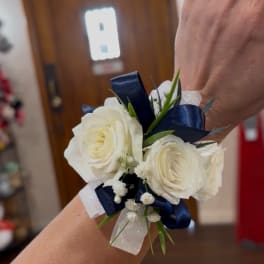 White rose wrist corsage with navy ribbon and baby's breath