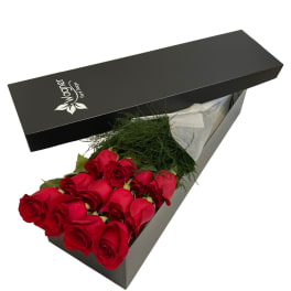 Box of red roses with greenery in a black gift box
