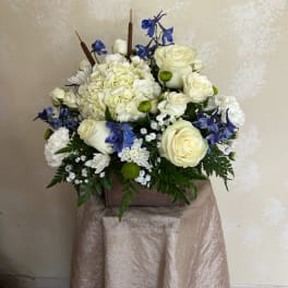 White and blue floral arrangement in a wooden box