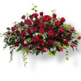 Large arrangement of red roses with greenery on a white background