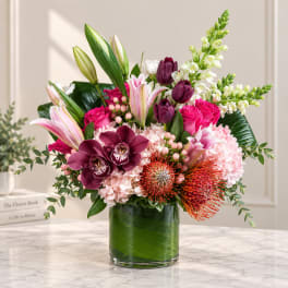 Mixed bouquet of pink, white, and purple flowers in a glass vase