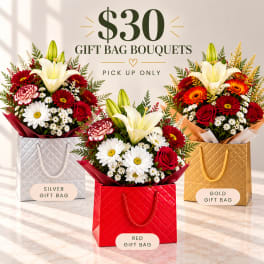 Three flower bouquets arranged in gift bags with a price sign above.