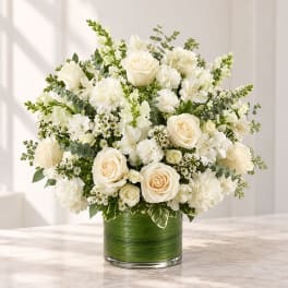 White floral arrangement in a green glass vase