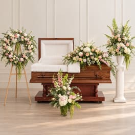 Floral funeral casket display with pink and white roses and greenery