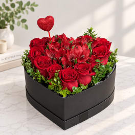 Heart-shaped box of red roses and red alstroemeria with a glitter heart pick