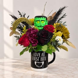 Bouquet with roses and mums in a black mug with a Frankenstein face topper