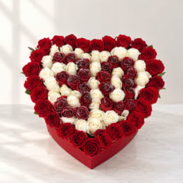 Heart-shaped box filled with red and white roses
