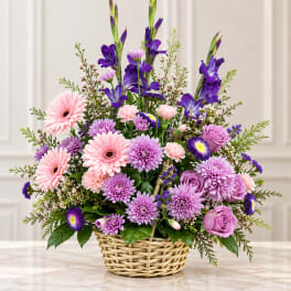 Basket arrangement of pink and purple flowers with tall purple spikes