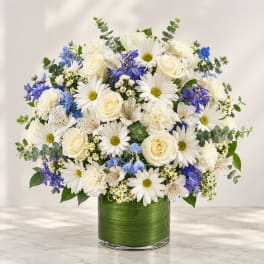 White and blue mixed bouquet in a green glass vase