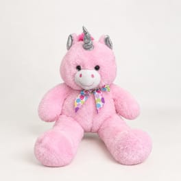 Pink plush unicorn teddy bear with a colorful ribbon bow
