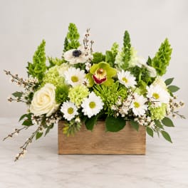 White and green floral arrangement in a wooden box