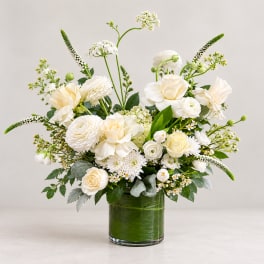 White floral arrangement in a green glass vase
