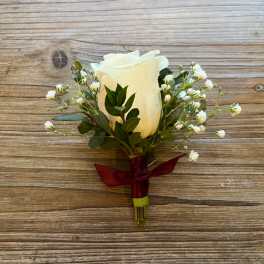 White rose boutonniere with baby's breath and burgundy ribbon