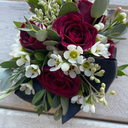 Compact bouquet of deep red roses and white blossoms with eucalyptus