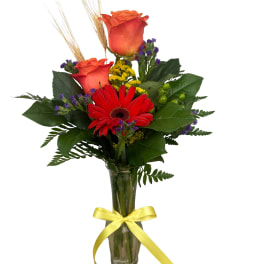 Bouquet of red roses and a red gerbera daisy in a glass vase
