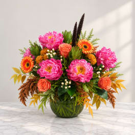 Bright mixed bouquet in a glass vase with pink blooms and orange flowers