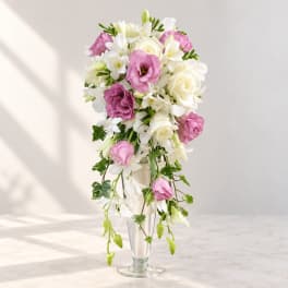 Pink and white bridal bouquet in a clear glass vase