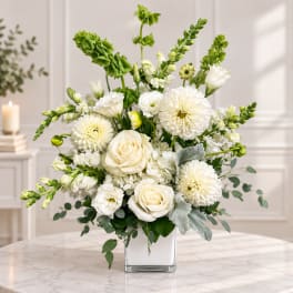 White roses and mums arranged in a clear square vase