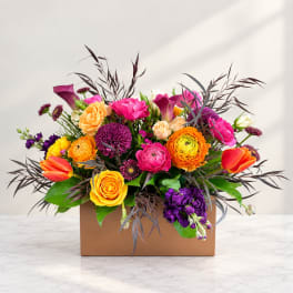 Colorful mixed bouquet in a brown box with tulips and roses
