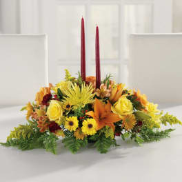 Autumn floral centerpiece with two red taper candles