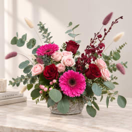Pink and red rose arrangement with gerbera daisies in a decorative vase