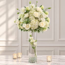 White rose and hydrangea arrangement in a tall glass vase