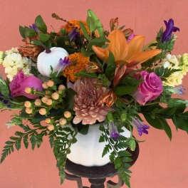 Mixed bouquet in a white vase with orange, pink, purple, and white flowers