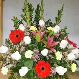 Large mixed floral arrangement with red gerberas, white roses, and pink lilies