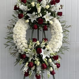 Standing floral wreath with red and white roses and lilies