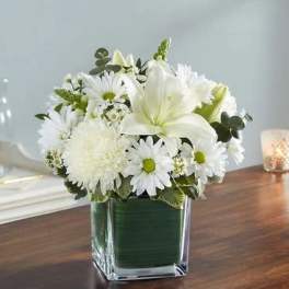 White floral arrangement in a square glass vase