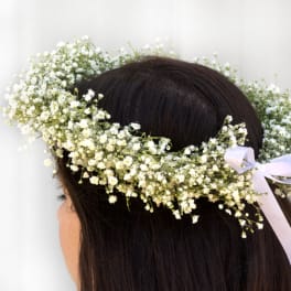 White baby's breath flower crown on a person's head with a ribbon tie