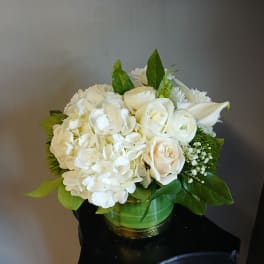 White floral arrangement in a green glass vase