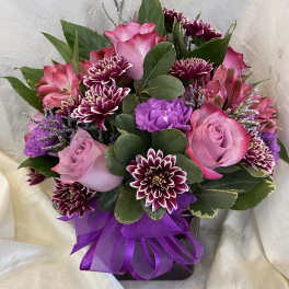 Pink and purple bouquet with roses and chrysanthemums tied with a purple ribbon