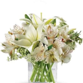 White lilies and alstroemeria in a clear glass vase
