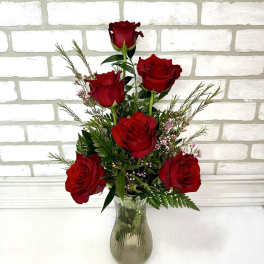 Red roses arranged in a clear glass vase