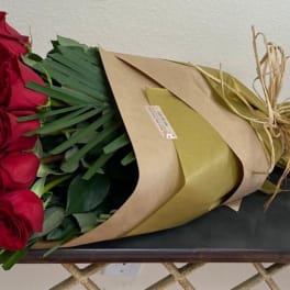 Bouquet of red roses wrapped in brown and gold paper
