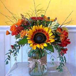Sunflower bouquet in a glass vase with orange and red flowers