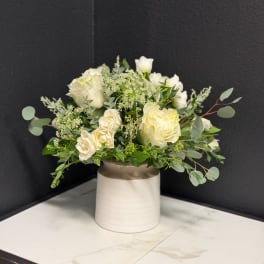 White rose bouquet in a cream ceramic vase