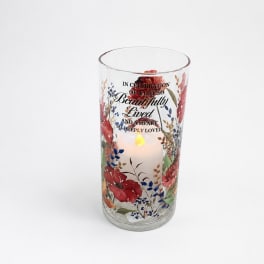 Glass memorial candle holder with floral print and lit candle
