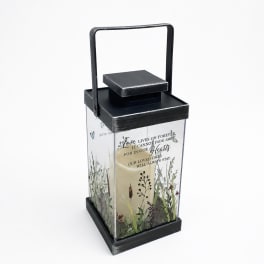 Black lantern with a candle and memorial text inside