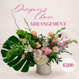 Mixed floral arrangement in a white vase with pink and green blooms